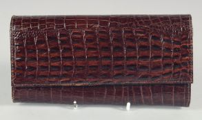 A 1940's - 1950's BLACK PATENT CROCODILE SKIN PURSE. 7.5ins long, 4ins deep.