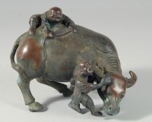 A CHINESE BRONZE OXON with two boys. 6ins long.