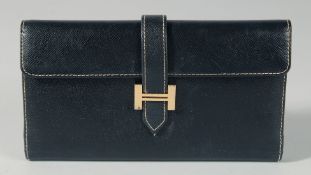 A HERMES BLACK LEATHER PURSE. 7ins long, 4ins deep.