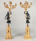 A GOOD PAIR OF EMPIRE DESIGN GILT BRONZE, BRASS AND BRONZE CANDLESTICKS, a classical figure