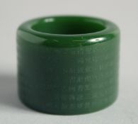 A CHINESE JADE ARCHER'S RING with calligraphy. 1.125ins.