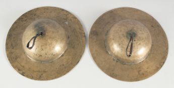 AN EARLY PAIR OF BURMESE BRASS CIRCULAR CYMBALS. 9.5ins diameter.