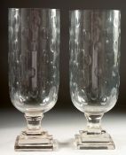 A PAIR OF SLICE CUT GLASS STORM LAMPS on square stepped bases. 15ins high.