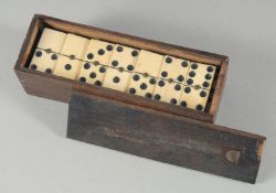 A BOX OF BONE DOMINOES.