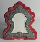 A GOOD SILVER SHAPED MIRROR in a velvet frame. 14ins x 13ins. London, 1932.