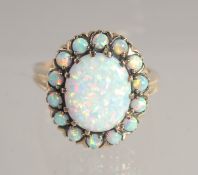 A 9CT GOLD GILSON OPAL CLUSTER RING.