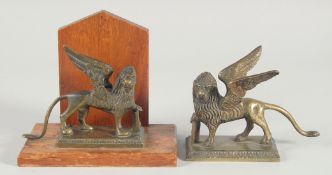 TWO BRASS EGYPTIAN LIONS one on a wooden base. 5ins.