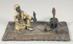A VIENNA PAINTED COLD CAST BRONZE GROUP, amulet vendor standing on Persian rug. 5.5ins high.