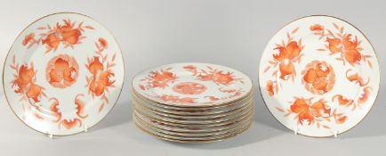 A SET OF TWELVE TEN-INCH ORANGE AND WHITE PORCELAIN PLATES.