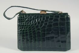 A 1950's - 1960's BLACK PATENT CROCODILE SKIN HANDBAG with gilt mounts, suede interior and a