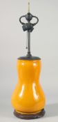 A CHINESE YELLOW PORCELAIN LAMP VASE on a wooden base. 13ins high.