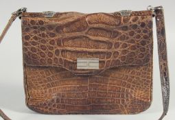 A 1940's - 1950's BROWN CROCODILE SKIN HANDBAG with chrome lock, fold over flap, fitted interior and