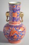 A CHINESE RED AND BLUE TWO HANDLED PORCELAIN VASE with elephant handles. 9.5ins high.