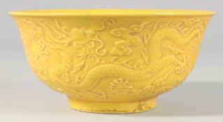 A CHINESE YELLOW PORCELAIN BOWL decorated with dragons. 6.25ins diameter.