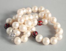 A STRING OF PEARLS WITH DIAMOND pendant and a gold clasp.