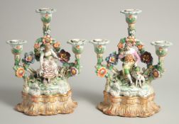 A VERY GOOD PAIR OF SAMSON CHELSEA DERBY PORCELAIN CANDLESTICK GROUPS. a woman with a lamb, a man