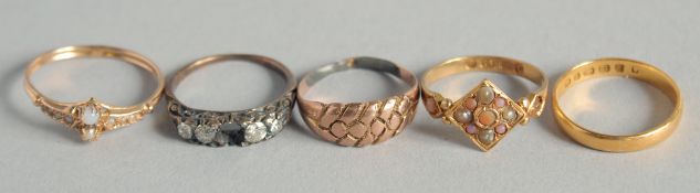 A 22CT GOLD WEDDING BAND and four various rings (5).