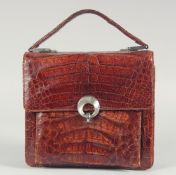 A 1940's - 1950's BROWN CROCODILE SKIN HANDBAG with chrome lock, fold over flap, leather and suede