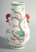 A CHINESE FAMILLE ROSE PORCELAIN DRAGON VASE with twin handles. 10ins high.