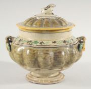 AN EARLY ENGLISH POTTERY CIRCULAR GLAZED BOWL AND COVER, the lid with a rabbit handle. 8.5ins deep.