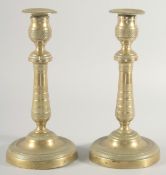 A GOOD PAIR OF EMPIRE CIRCULAR CHASED CANDLESTICKS. 9.5ins high.