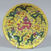 A CHINESE FAMILLE JAUNE CIRCULAR PORCELAIN DISH decorated with dragons. 8ins diameter.