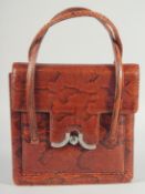A 1940's - 1950's SNAKESKIN HANDBAG with chrome lock, fitted leather interior with a purse, complete