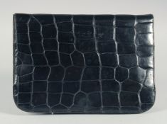 A 1940's - 1950's BLACK PATENT CROCODILE SKIN CLUTCH BAG with fold over flap and fitted interior.