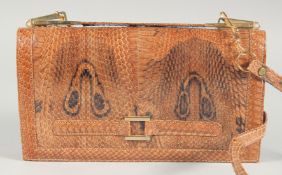 A 1940's - 1950's SNAKESKIN HANDBAG the skin showing two eyes with gilt mount, fold over front and