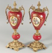 A SMALL PAIR OF LOUIS XVI RED PORCELAIN GILT METAL URN SHAPED VASES AND COVERS. 18.5ins high.