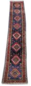 A PERSIAN DESIGN RUNNER, dark blue ground with eight medallions. 14ft 8ins x 3ft.