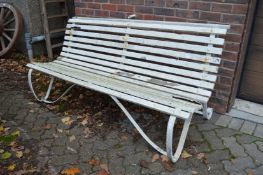A wrought iron and white painted slatted garden bench.