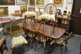 An ercol refectory style dining table together with a set six ercol chairs, two with arms and a pair