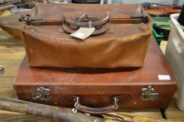 A leather doctors bag and a suitcase.