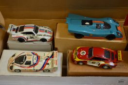 Four boxed Porsche model racing cars.