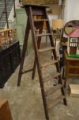 An old pair of Stephens and Carter wooden step ladders, broad arrow mark and G R ciphers.