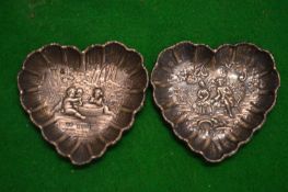 A pair of cast silver heart shaped dishes.