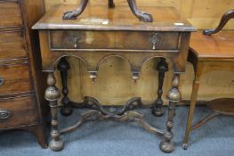 A 17th century style walnut single drawer side table on turned legs united by an X-shaped
