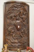 A good large bow fronted carved wooden plaque depicting cherubs.