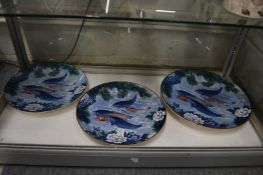 Three large Japanese plates depicting fish.