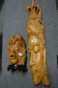 A large Eastern carved wood bust together with another bust.