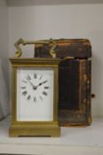 A brass carriage clock with leather travelling case.