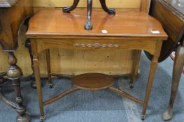 An Edwardian mahogany fold-over card table.