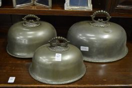 A graduated set of three pewter meat domes.