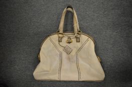 A ladies large beige leather bag.