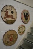 Four decorative painted circular wooden plaques.