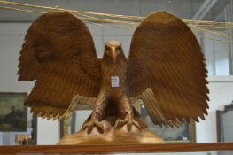 A large carved wood eagle with wings out spread.