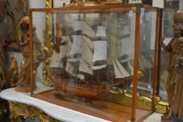 A large model of the sailing ship Superbe in a glazed display case.