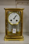 A brass four glass mantel clock.