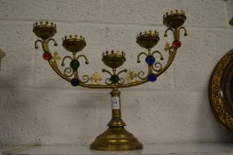 A brass five light candelabra inset with coloured glass cabochons.